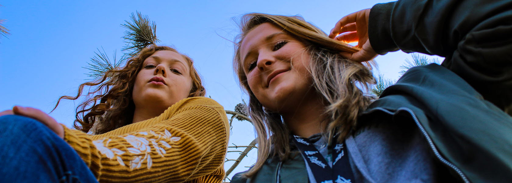 Två unga tjejer tittar ner på fotografen