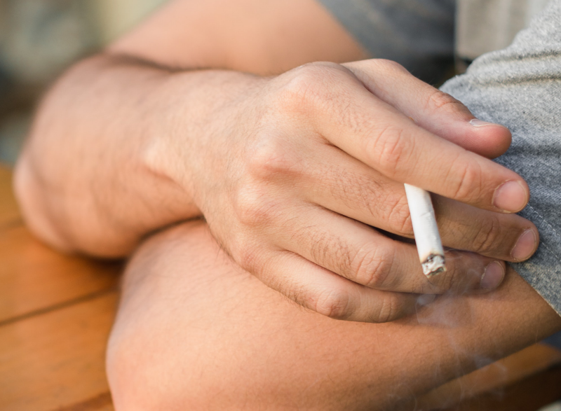 Person med cigarett i handen